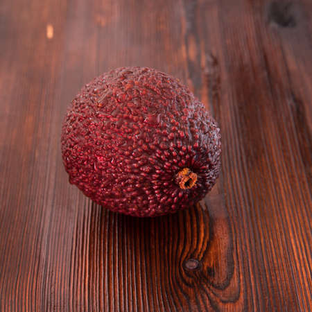 Avocado Hass with water drops on a wooden table close-up, copy space, templateの写真素材