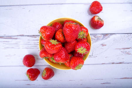 Strawberries on a plate on a white table, top view, copy spaceの写真素材
