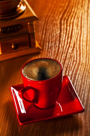 cup of cappuchino and coffee grinder on wooden boardの写真素材
