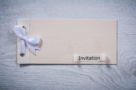 vintage invitation note on old gray wooden board