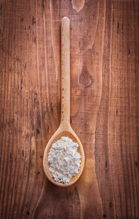 flour in wooden spoon on old boardの写真素材