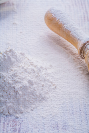 little pile of white natural flour and wooden rolling pin verticの写真素材