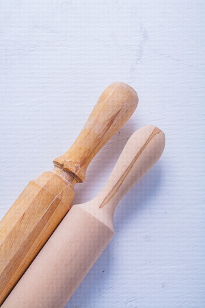 two rolling pins on white painted wooden boardの写真素材