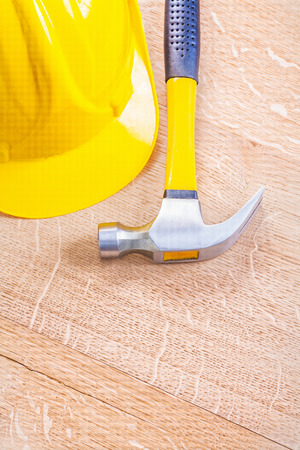 yellow hardhat and claw hammer on vintage wooden board copyspaceの写真素材