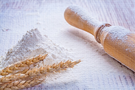 wooden rolling pin and heap flour with ears of  wheat on vintageの写真素材