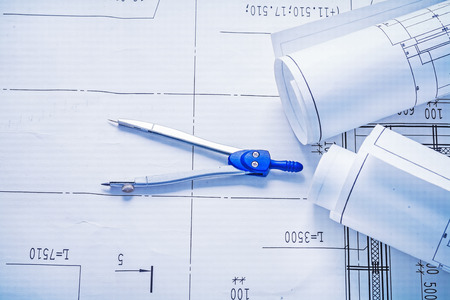 compass and two rolled up white blueprints horizontal versionの写真素材