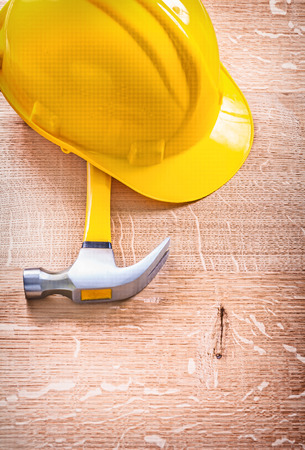 claw hammer and yellow helmet on wooden board construction conceの写真素材