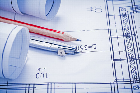 rolled blueprints pencil compass close upの写真素材