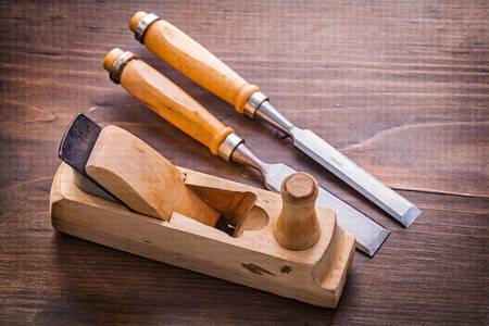 woodworkers plane and chisels on vintage wooden board
