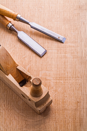 old woodworkers plane and carpentry chisel on wooden boardの写真素材
