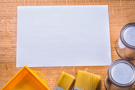 white blank sheet of paper on wooden board with paint brushes tr