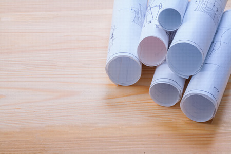 big stack of rolls blueprints on wooden board with organized copの写真素材