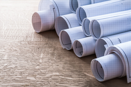 Collection of blueprint rolls on wooden oaken board constructionの写真素材
