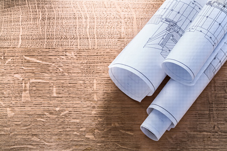 Rolls of blueprints on wooden oaken board construction conceptの写真素材