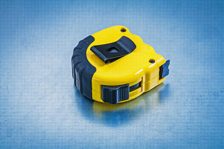 Measuring tape on metallic background construction concept
