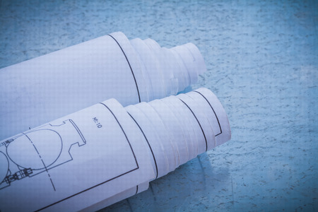 Rolled construction drawings on metallic background horizontal view building and architecture...