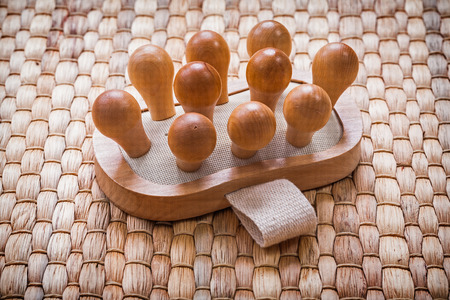 Single wooden massager with elastic band on wicker mat healthcare conceptの写真素材