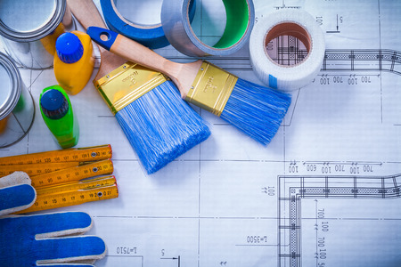 Wooden meter household tapes safety gloves and paint tools on blueprint maintenance concept.の写真素材