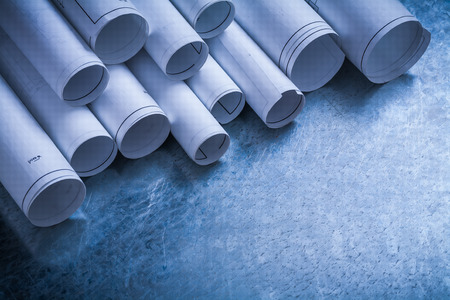 Rolls of white construction drawings on scratched metallic background building and architecture concept.の写真素材
