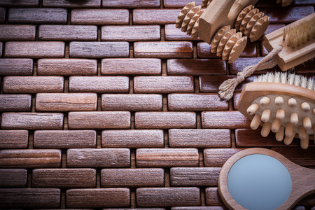 Looking-glass massagers and peeling brushes on textured wooden table mat sauna concept.の写真素材