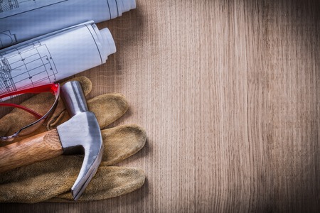 Construction drawings plastic protective glasses hammer and leather safety gloves.の写真素材