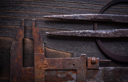 Set of rusted vernier calipers on vintage wooden background.の写真素材