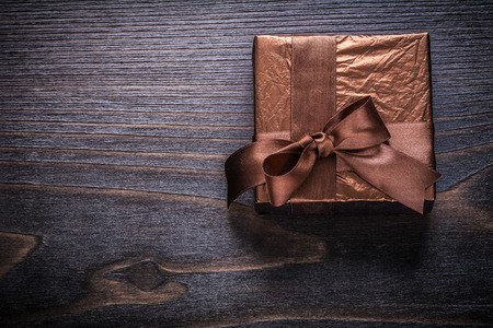 Boxed gift wrapped in glittery paper on vintage wood board.の写真素材