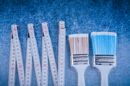 Composition of wooden meter paint brushes on scratched metallic background.の写真素材