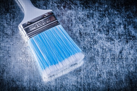 Paintbrush on scratched metallic background top view image construction concept.の写真素材