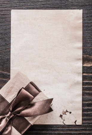 Wrapped giftbox paper on vintage wooden board vertical version.の写真素材