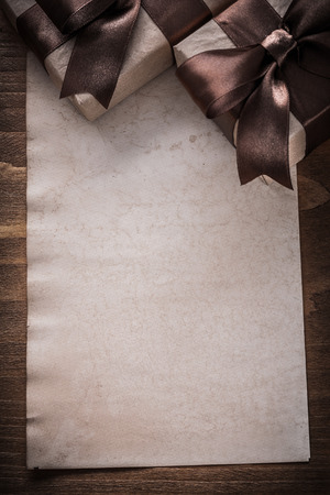 Wrapped giftboxes paper on vintage wooden board holiday concept.の写真素材