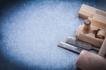 Wooden planer hammer bricks firmer chisels on metallic background copyspace.の写真素材