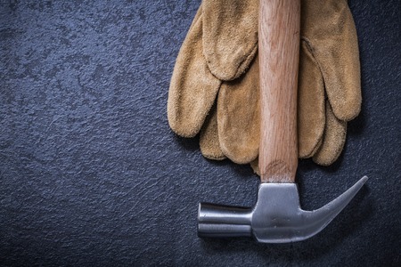 Leather safety gloves claw hammer on black background construction concept.の写真素材