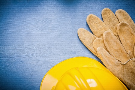 Hard hat safety gloves on wooden board horizontal version.