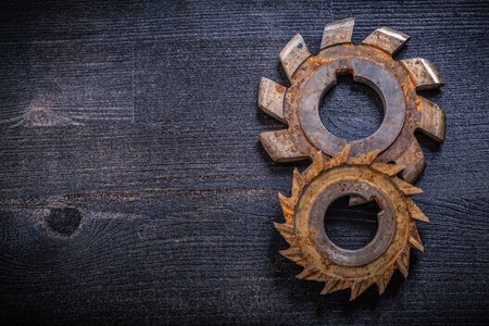 Rusty obsolete rotary cutters on wooden surface construction concept.の写真素材