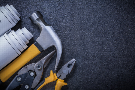 Construction plans steel cutter pliers claw hammer on black background.の写真素材