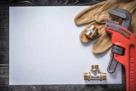 Monkey wrench brass plumbing fittings leather safety gloves blank paper.