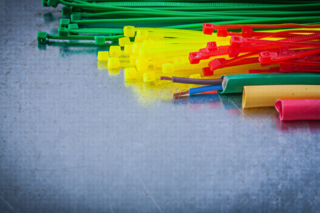 Collection of plastic cable ties electric wires on metallic background.