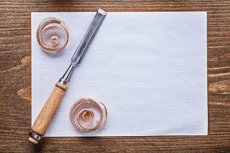 Sheet of paper curled shavings firmer chisels construction concept.