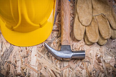 Claw hammer hard hat leather gloves on chipboard construction concept.の写真素材