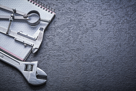 Divider calliper adjustable spanner notebook construction concept.