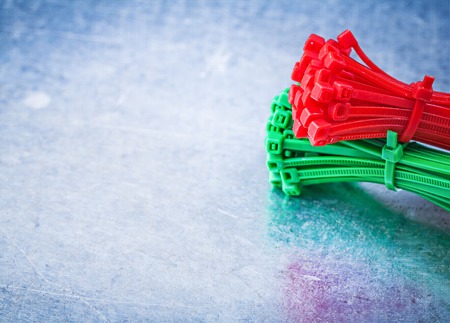 Bunch of self-locking cable ties on metallic background construction concept.
