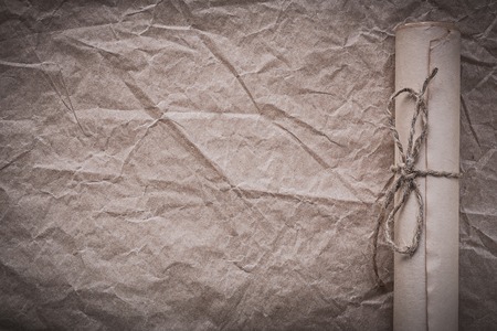 Medieval paper scroll on crumpled wrapping sheet.
