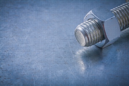 Steel threaded bolt and screw-nut on metallic background construction concept.の写真素材