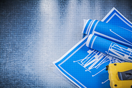 Composition of blue construction plans measuring tape on metallic background.の写真素材