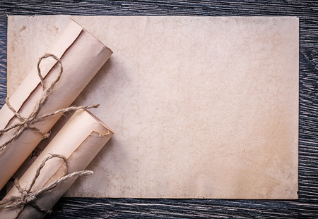 Vintage rolled up corded paper on wooden background.