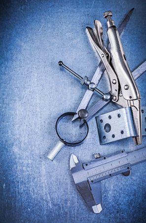 Metal lock jaw pliers trammel caliper drilled angle bars construction drawing compass on metallic background.の写真素材