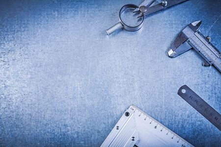 Metal construction drawing compass ruler vernier caliper try square on metallic background.の写真素材