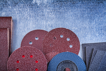 Collection of abrasive tools on metallic background top view.