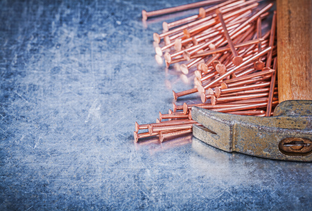 Vintage claw hammer copper construction nails on metallic background.の写真素材